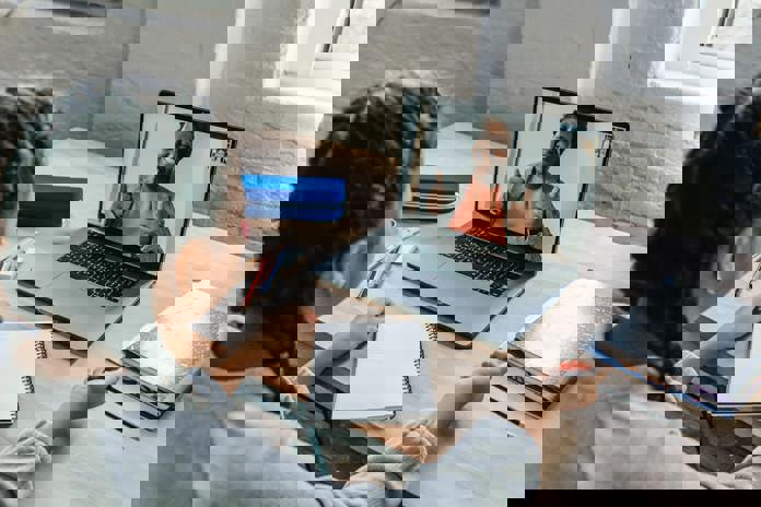 Girl on a video call with a co-worker both looking happy.