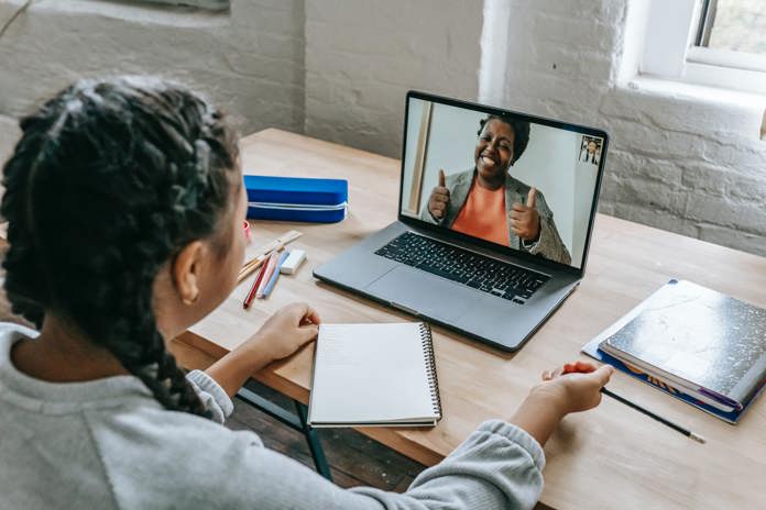 Girl on a video call with a co-worker both looking happy.