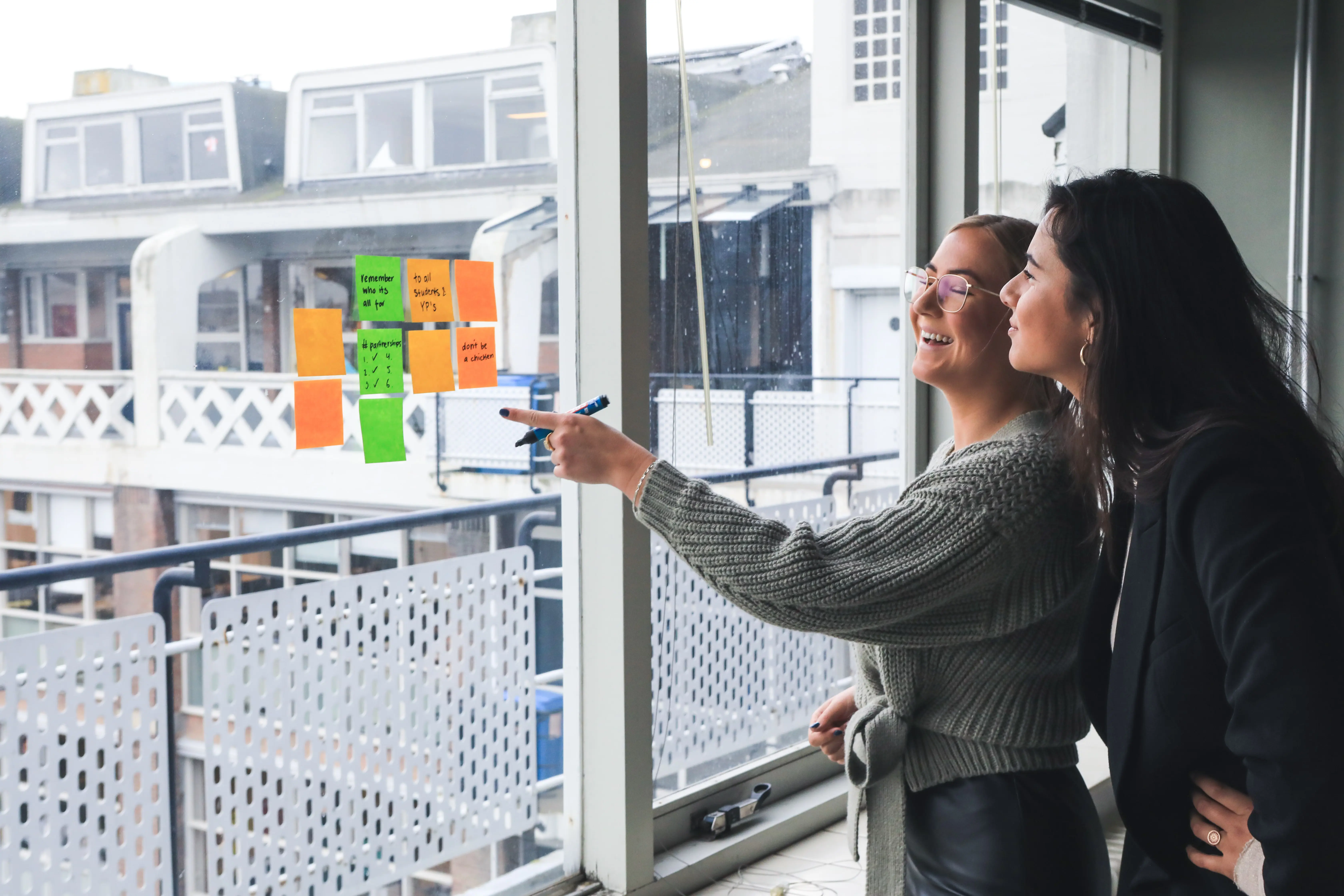 two female employees discussing and brainstorming with sticky notes
