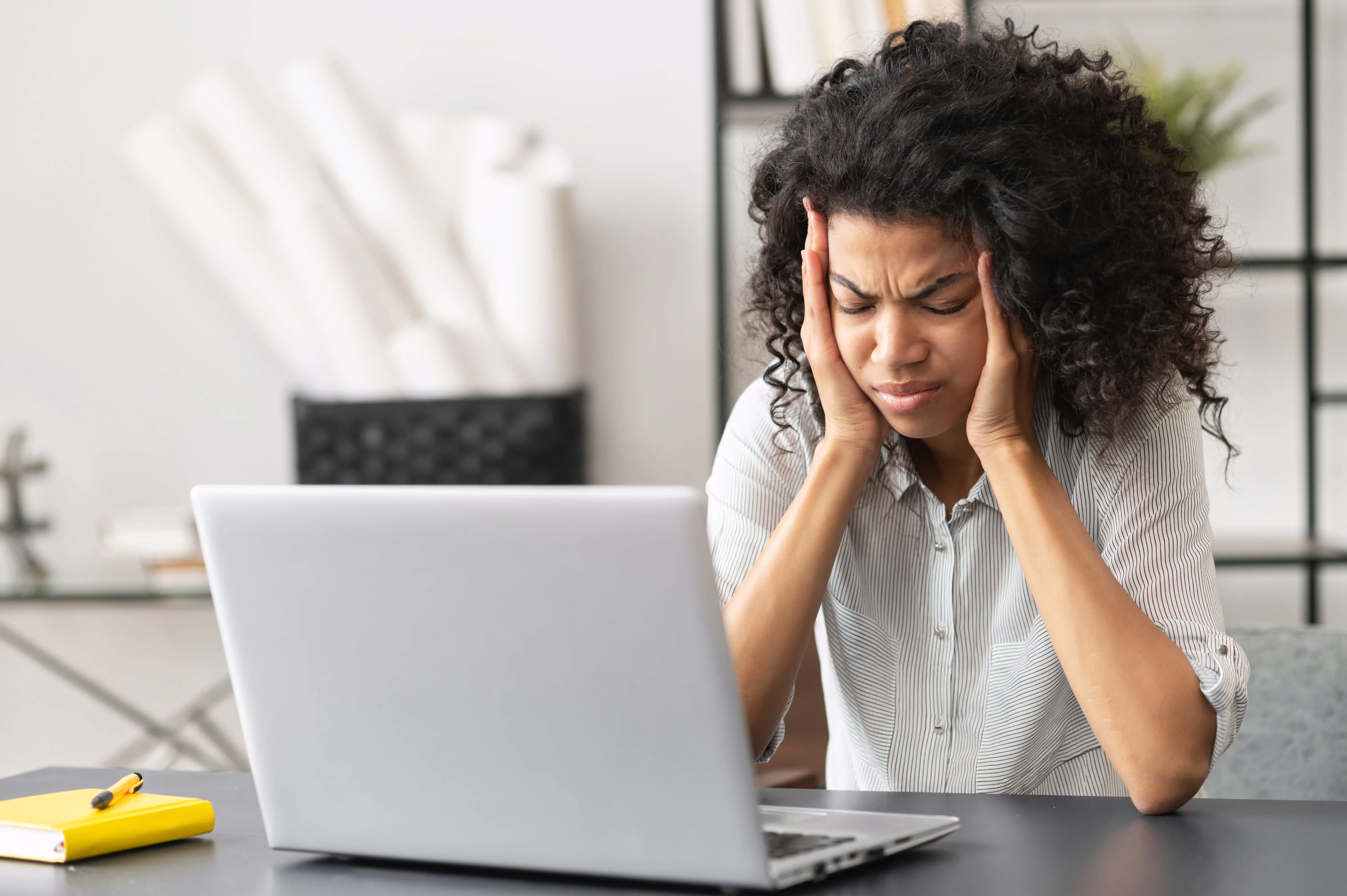 female worker sat in front of a laptop showing disappointment