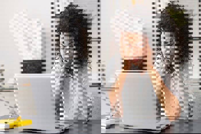 female worker sat in front of a laptop showing disappointment