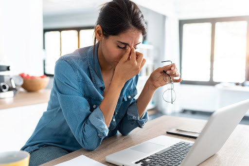 Employee sitting behind laptop with a stressful expression