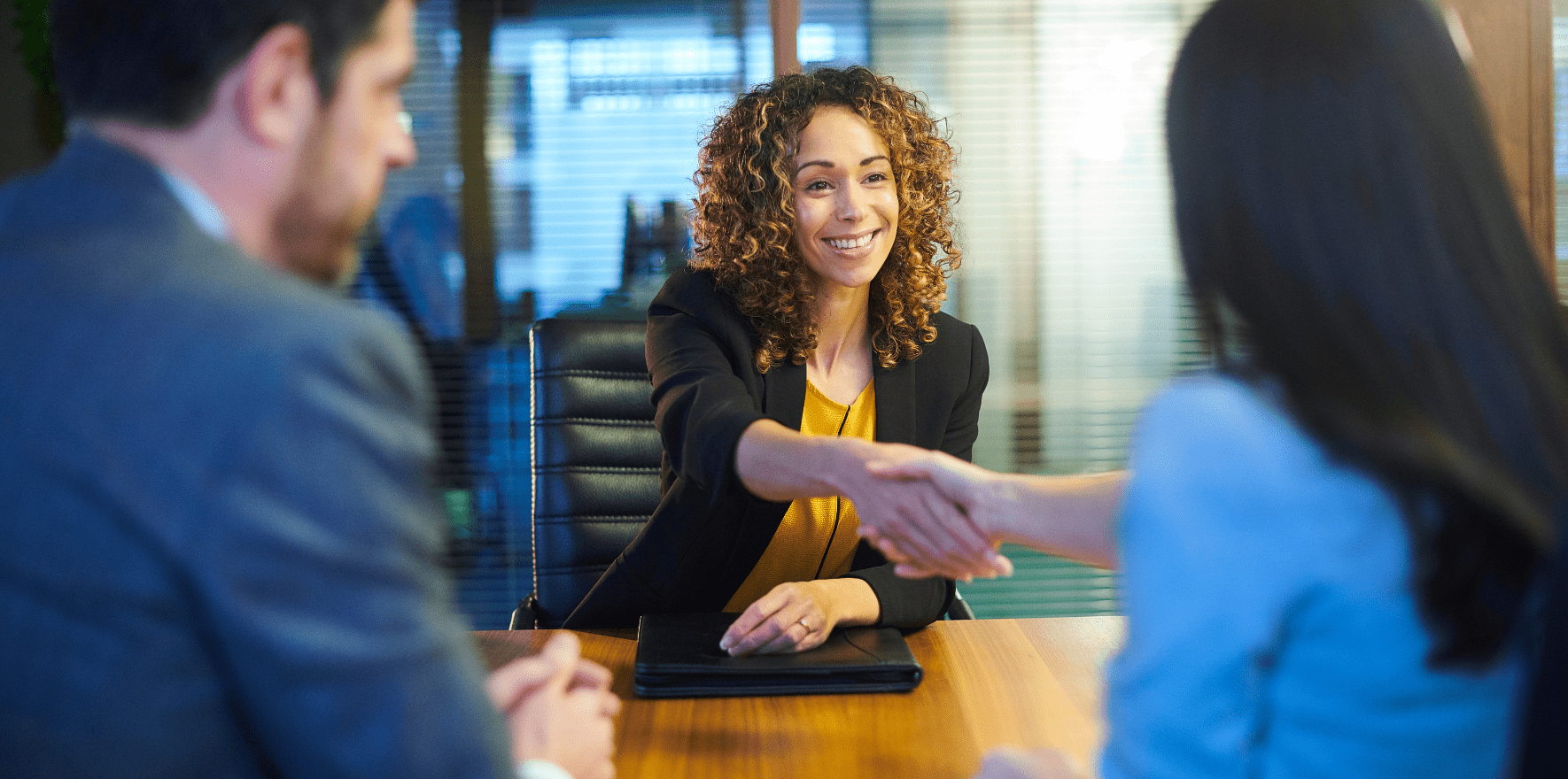 woman of colour shaking hands during a job interview