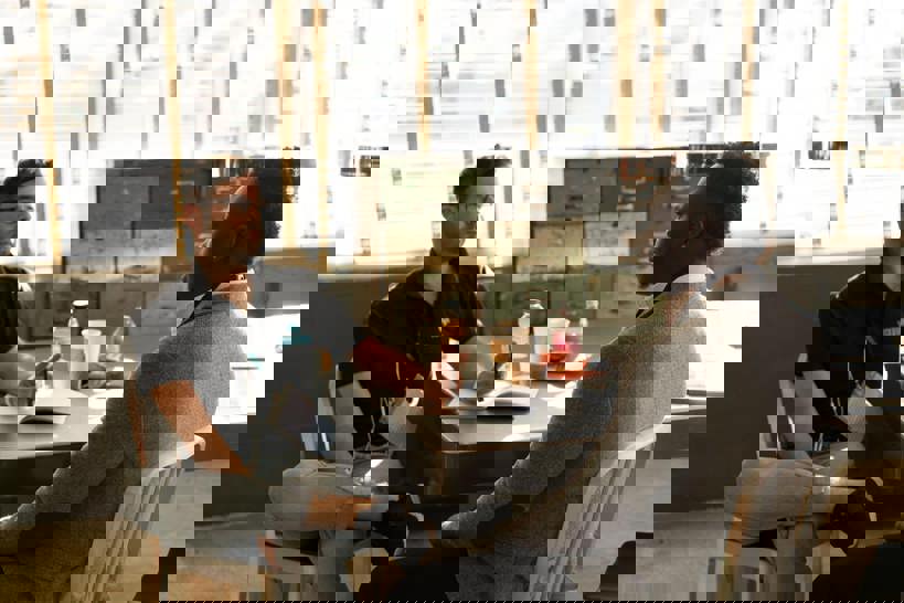 Two men sitting at a table having a formal work conversation.