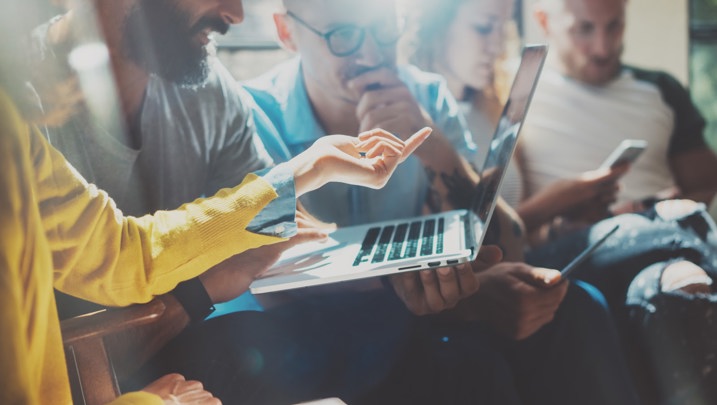 Colleagues share discussion over laptop