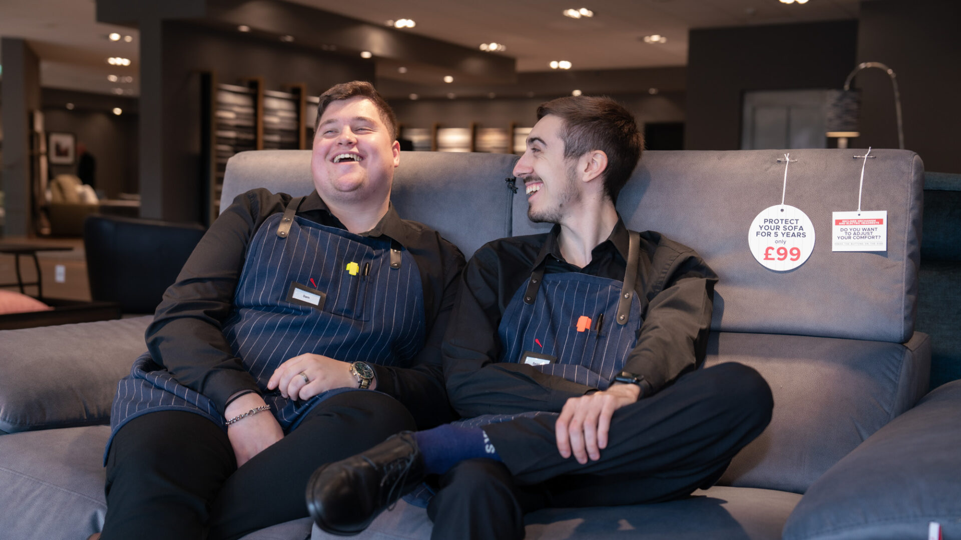 Two employees sitting on a sofa laughing