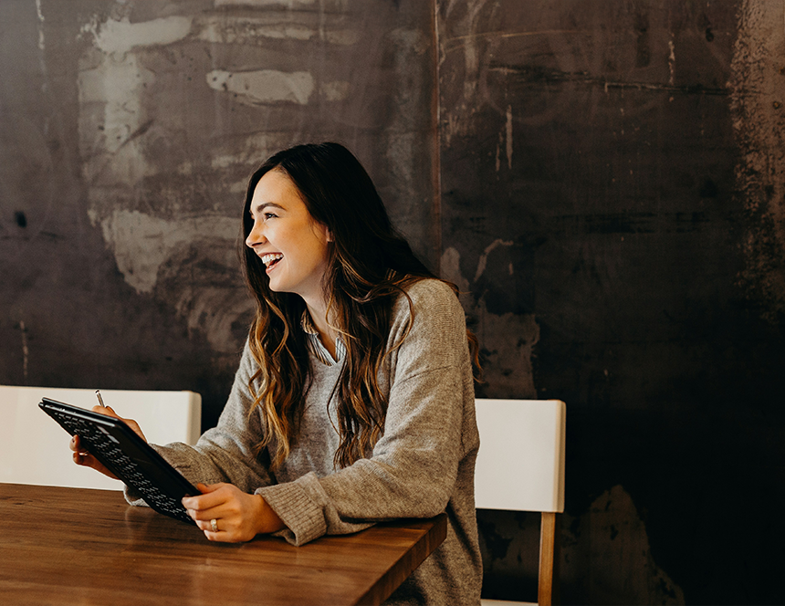 person smiling looking at tablet